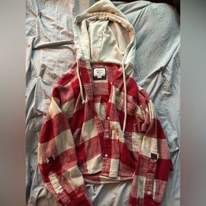 Red and white flannel hoodie with green and red flannel patches on the elbows
